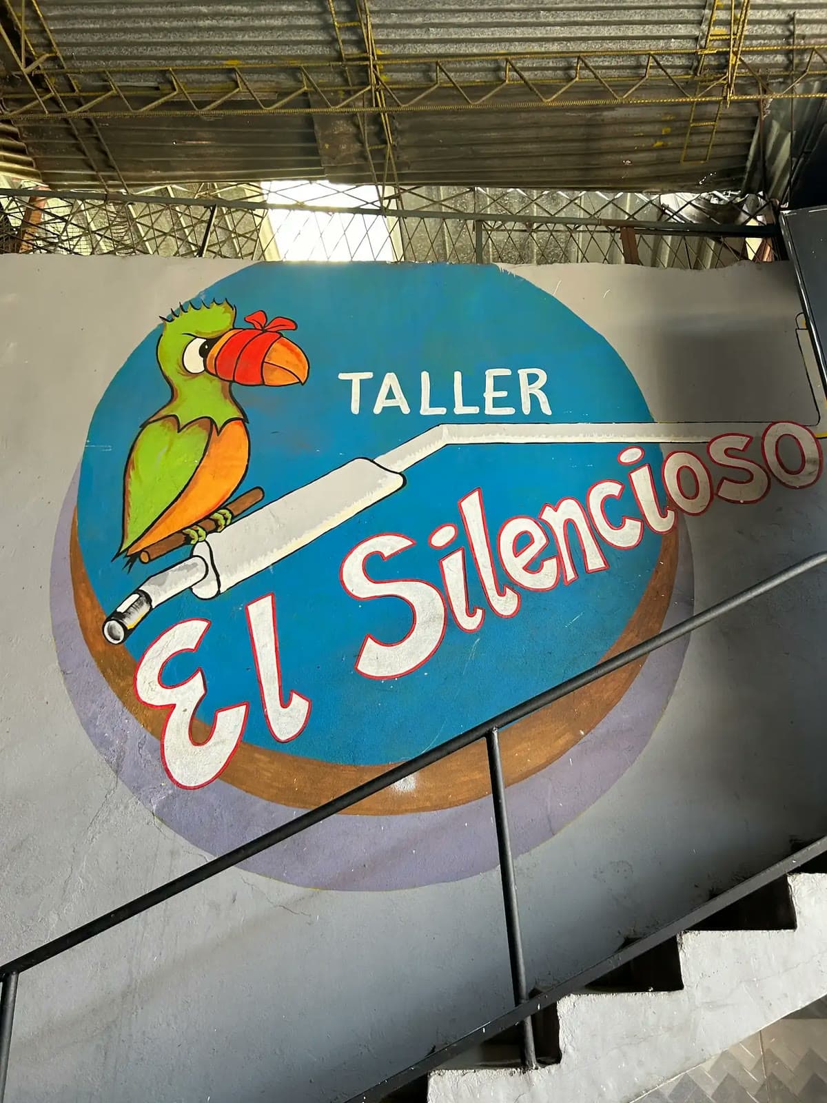 Aviso pintado a mano del Taller el Silencioso con el loro sobre el exosto